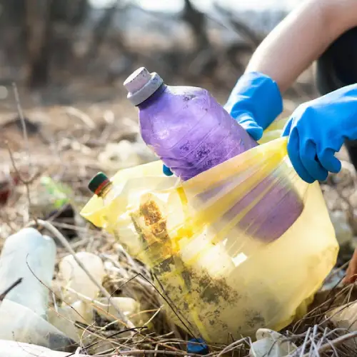 Volunteer picking up plastic rubbish bottles